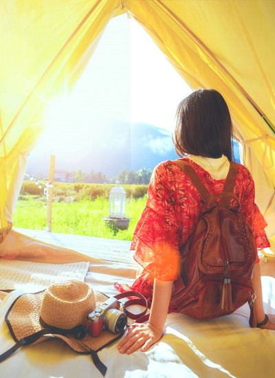 Voyageuse contemplant les montagnes depuis une tente