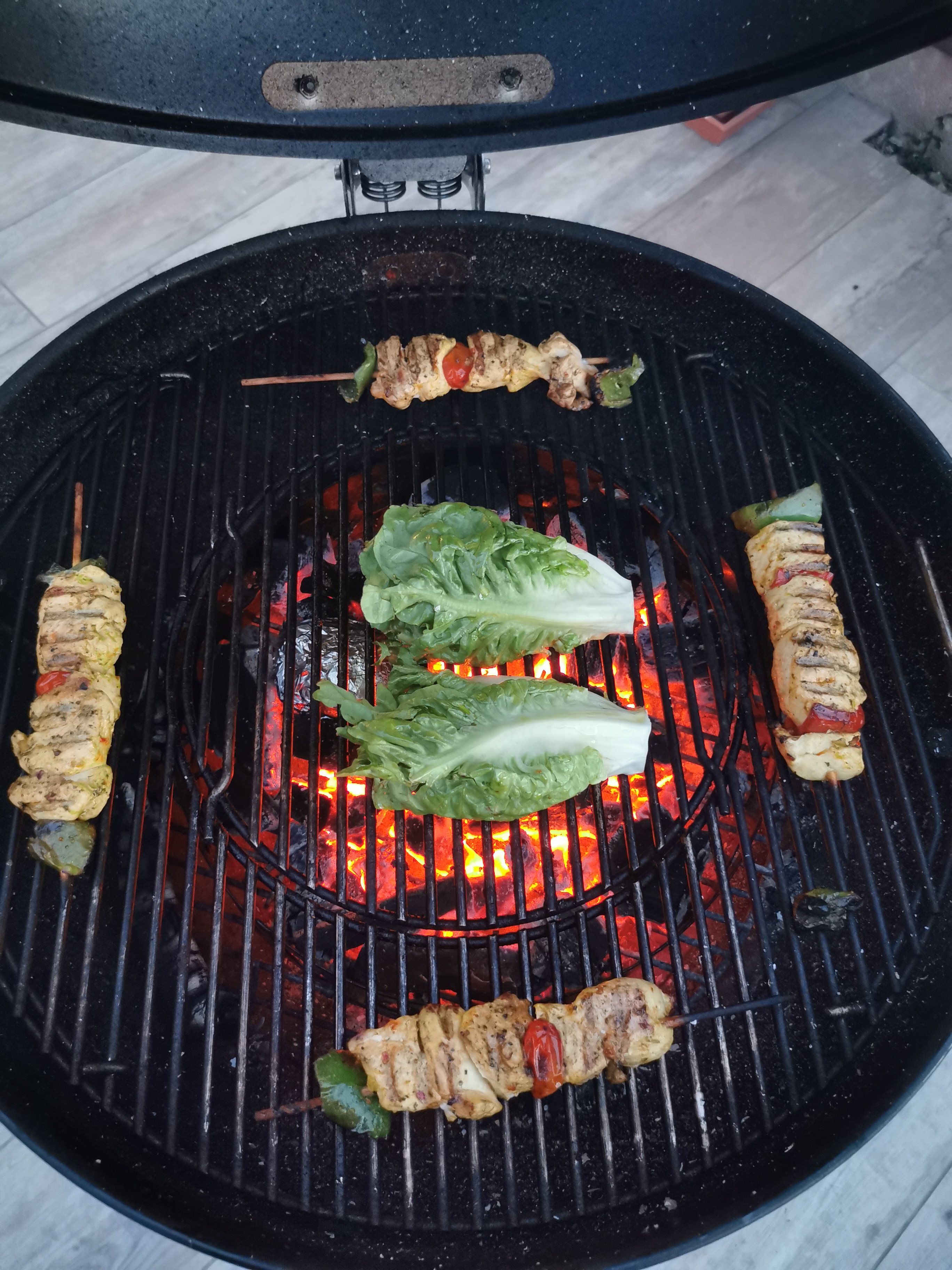 Brochettes de poulet au barbecue, sucrine braisée, pomme de terre à la cendre